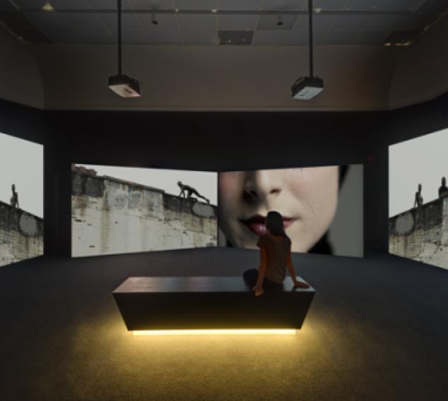 Person sitting in dark gallery space